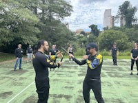 two men are holding swords in front of a group of people